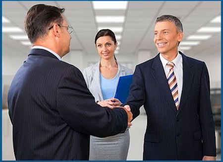 two men shaking hands and smiling