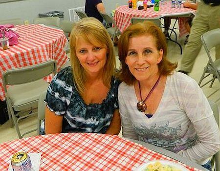 two women sitting at a table smiling