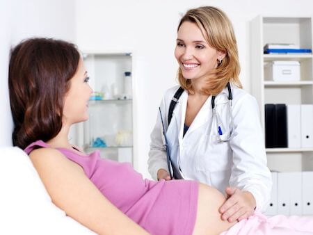 pregnant woman visiting with her doctor