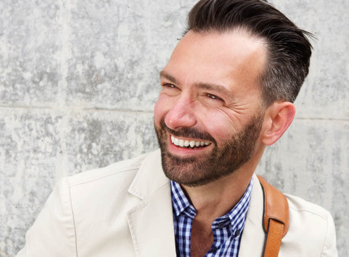 Dental Bridges patient model in a white jacket smiling